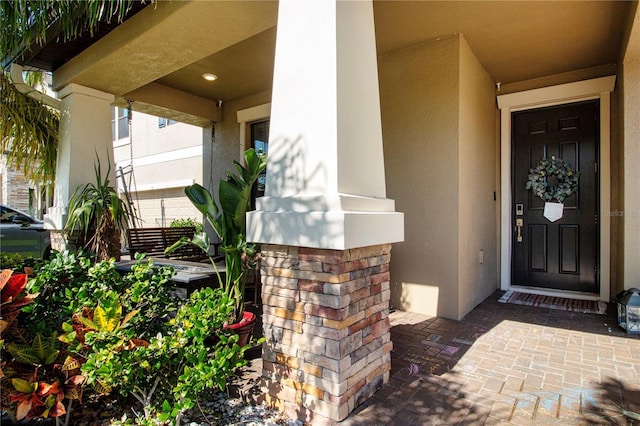 entrance to property featuring stucco siding