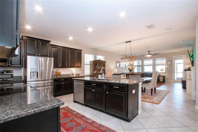 kitchen featuring a sink, a ceiling fan, stainless steel appliances, and a wealth of natural light