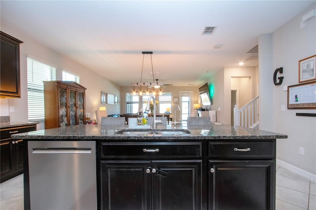 kitchen with visible vents, stainless steel dishwasher, a sink, light tile patterned floors, and dark cabinetry
