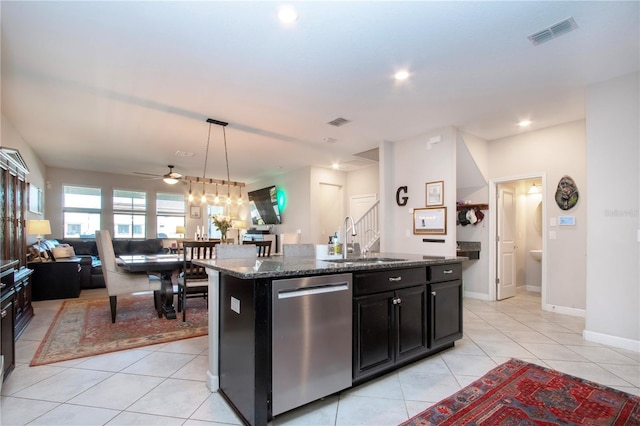 kitchen featuring visible vents, light tile patterned flooring, dark cabinets, a sink, and dishwasher
