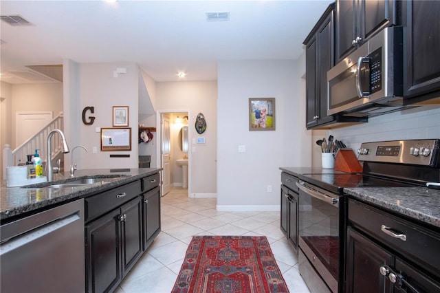 kitchen featuring visible vents, a sink, dark stone countertops, and appliances with stainless steel finishes
