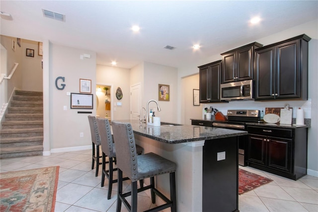 kitchen with a sink, light tile patterned floors, stainless steel appliances, and visible vents