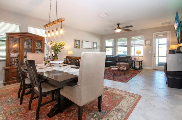 dining space featuring light tile patterned flooring, ceiling fan, visible vents, and baseboards