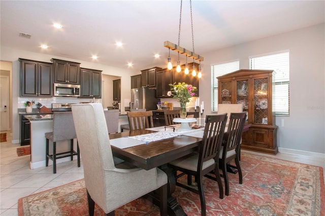 dining space with baseboards, visible vents, and light tile patterned floors
