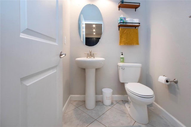 half bath featuring toilet, tile patterned floors, and baseboards