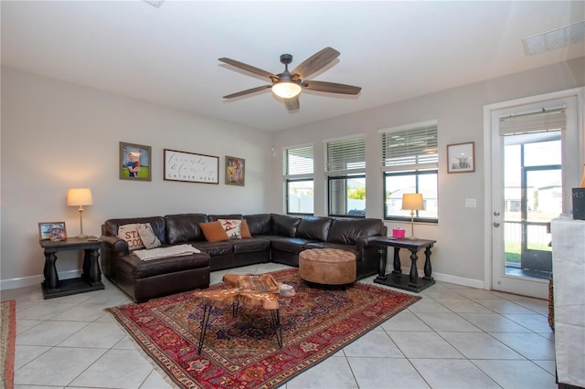 living area featuring baseboards, ceiling fan, visible vents, and light tile patterned floors