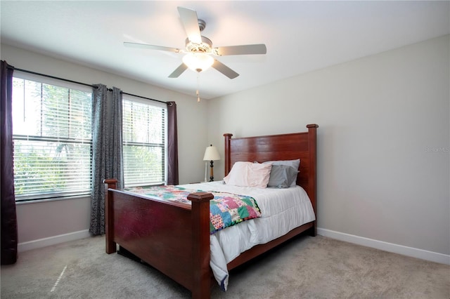 carpeted bedroom featuring baseboards and a ceiling fan