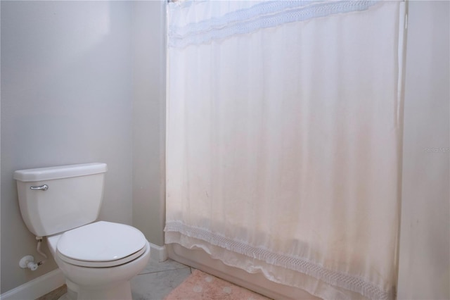 bathroom with baseboards, tile patterned floors, and toilet