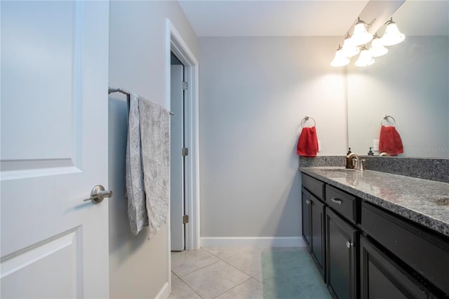 bathroom featuring an inviting chandelier, vanity, tile patterned flooring, and baseboards