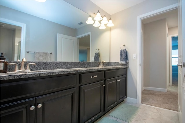 full bath with double vanity, visible vents, a sink, and an inviting chandelier