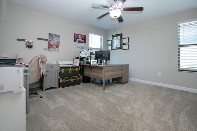 office area featuring baseboards, ceiling fan, and light carpet