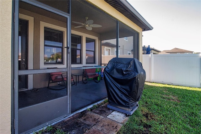 view of patio / terrace featuring grilling area, fence, a ceiling fan, and a sunroom