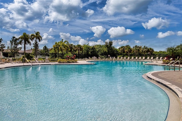 community pool with a patio and fence