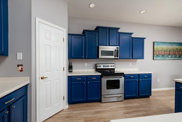 kitchen with light countertops, blue cabinetry, appliances with stainless steel finishes, and light wood-type flooring