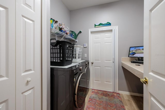washroom featuring light wood-style floors, baseboards, laundry area, and washer and clothes dryer