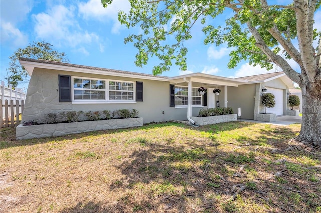 ranch-style house featuring stucco siding, fence, a front lawn, and a garage