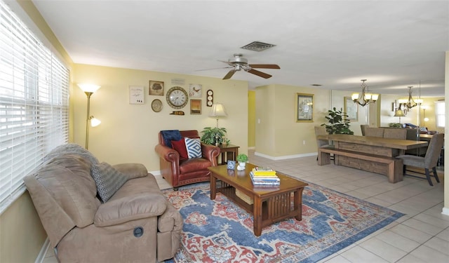 tiled living room with visible vents, baseboards, and ceiling fan with notable chandelier