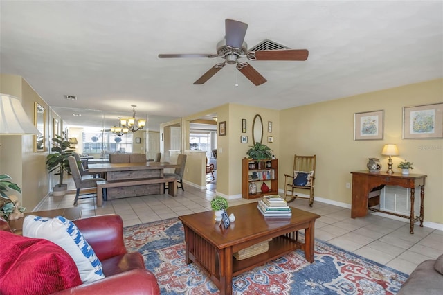living area with tile patterned floors, visible vents, baseboards, and ceiling fan with notable chandelier