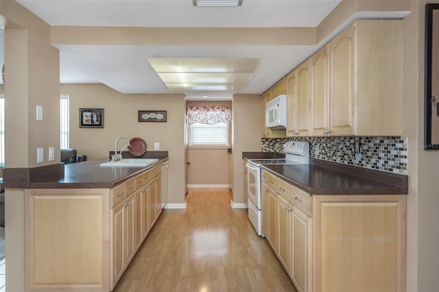 kitchen featuring white appliances, light brown cabinetry, and a sink