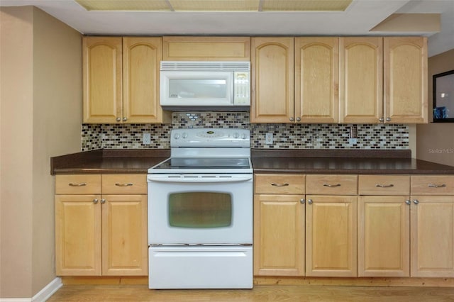 kitchen featuring white appliances, dark countertops, light wood-style flooring, and light brown cabinets