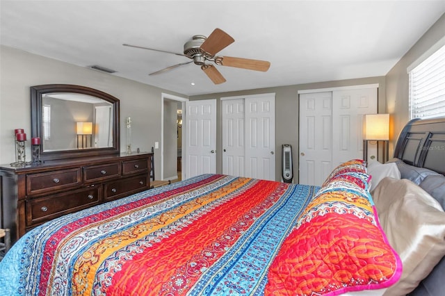 bedroom featuring two closets, a ceiling fan, and visible vents