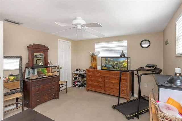 workout area featuring carpet flooring, ceiling fan, and visible vents