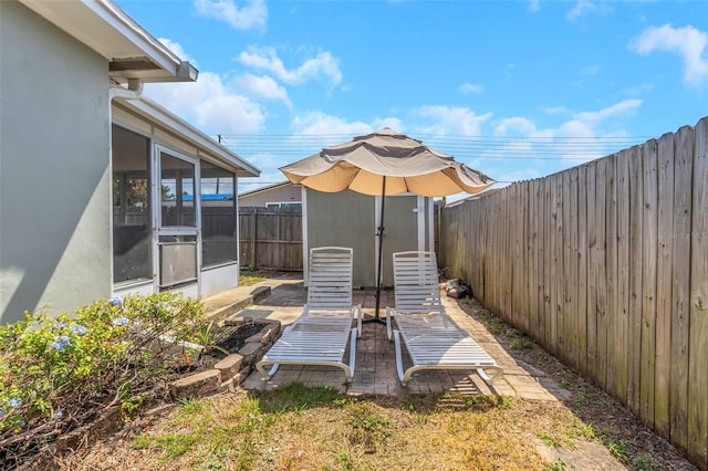 view of yard featuring a fenced backyard, an outdoor structure, a sunroom, and a shed