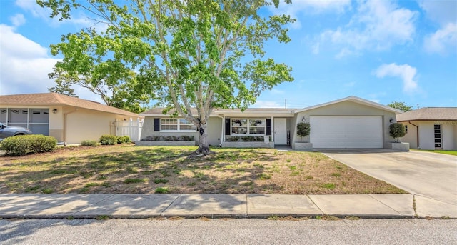 ranch-style house with a garage, stucco siding, and concrete driveway