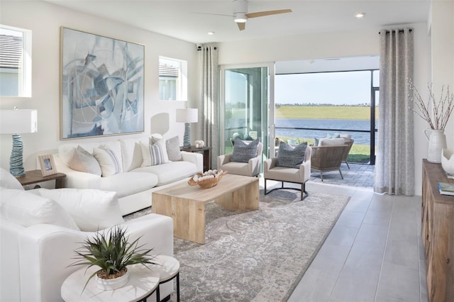 living room with recessed lighting, ceiling fan, and a water view