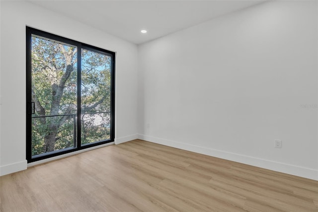 empty room featuring baseboards and light wood-style flooring