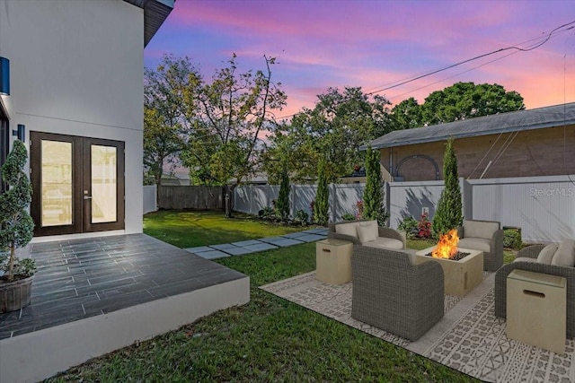 view of yard with a fenced backyard, a fire pit, a patio area, and french doors