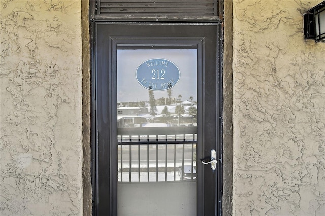 view of exterior entry featuring stucco siding