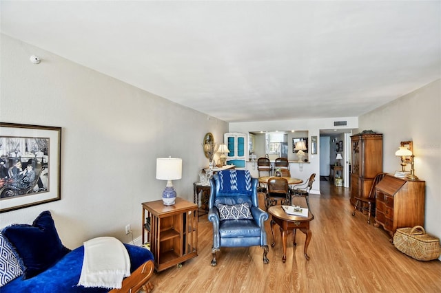 living area featuring visible vents and wood finished floors