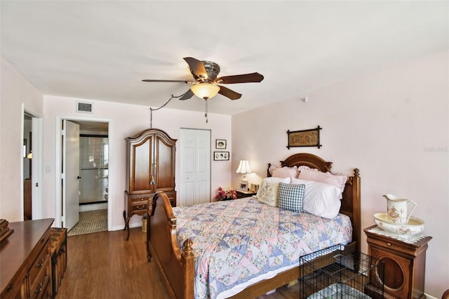 bedroom featuring ensuite bathroom, a closet, visible vents, dark wood-style flooring, and a ceiling fan