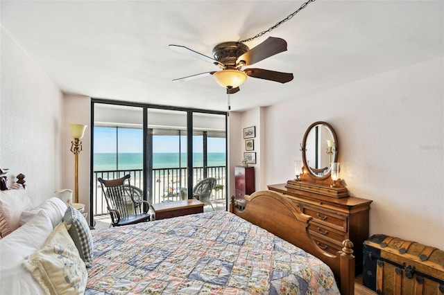bedroom with expansive windows, a water view, access to outside, and a ceiling fan