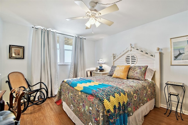 bedroom featuring baseboards, ceiling fan, and wood finished floors