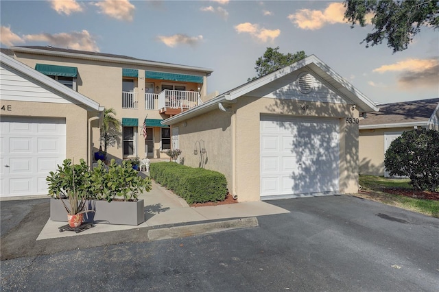 view of front of property featuring an attached garage, driveway, and stucco siding