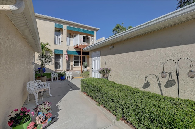 property entrance featuring a balcony and stucco siding