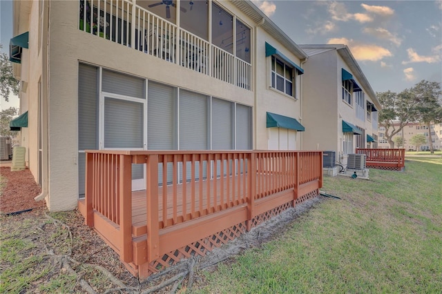 6330 99th Way N Unit 14F, Saint Petersburg, FL 33708 - view of side of home featuring stucco siding, a yard, a deck, and central AC unit