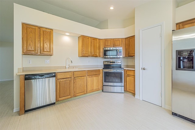 29436 Zeller Ave, San Antonio, FL 33576 - kitchen featuring stainless steel appliances, a sink, brown cabinetry, light countertops, and recessed lighting