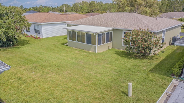 29436 Zeller Ave, San Antonio, FL 33576 - back of property with stucco siding, a yard, a shingled roof, and a sunroom