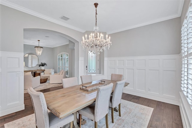 dining room featuring visible vents, arched walkways, wainscoting, and an inviting chandelier