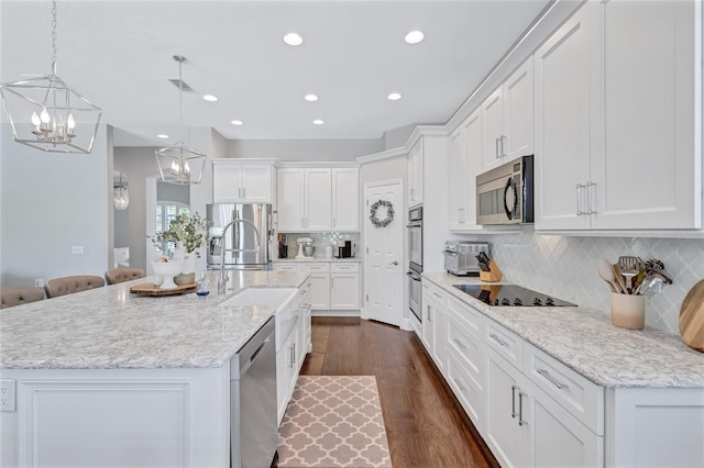 kitchen featuring appliances with stainless steel finishes, a chandelier, recessed lighting, white cabinetry, and dark wood-type flooring