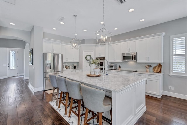 kitchen featuring stainless steel appliances, baseboards, visible vents, and white cabinetry