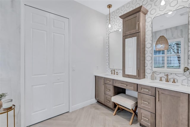 bathroom featuring double vanity, baseboards, and a sink