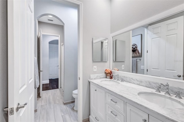 full bath featuring visible vents, a sink, double vanity, and toilet