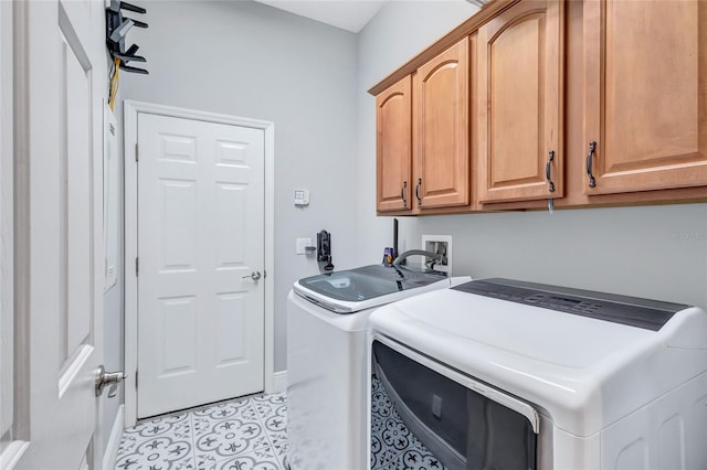 clothes washing area with baseboards, washer and clothes dryer, cabinet space, and light tile patterned floors