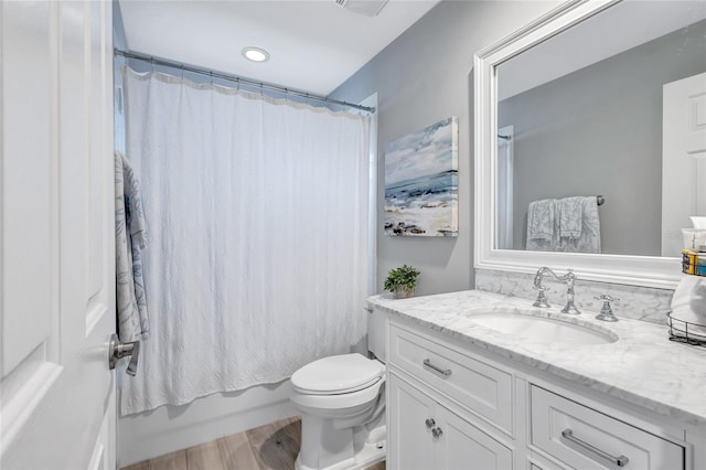 full bath featuring vanity, shower / tub combo, wood finished floors, and toilet
