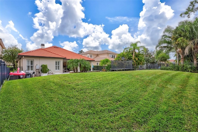 view of yard with a fenced backyard and a trampoline