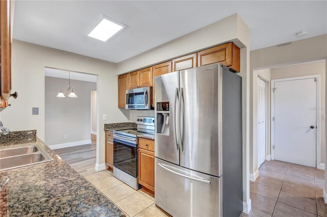 2961 Briar Cliff Dr, Palm Harbor, FL 34684 - kitchen with a sink, baseboards, an inviting chandelier, stainless steel appliances, and light tile patterned flooring